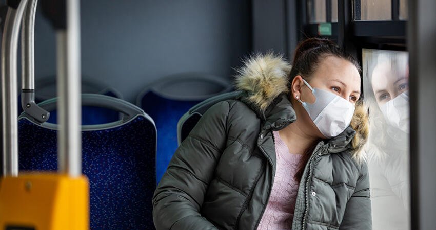 Woman rides bus wearing a mask