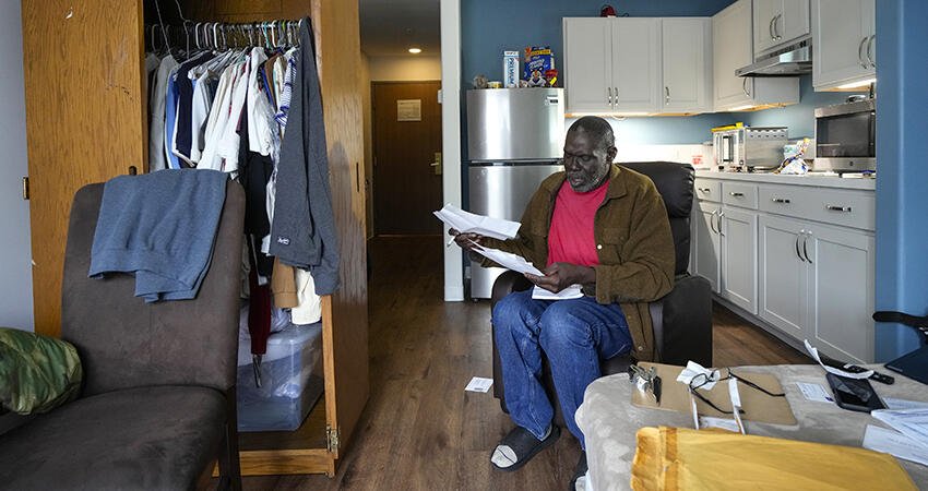 Army veteran Reggie Austin sits in his apartment looking at some paperwork at the newly-opened Tunnel to Towers Veterans Village