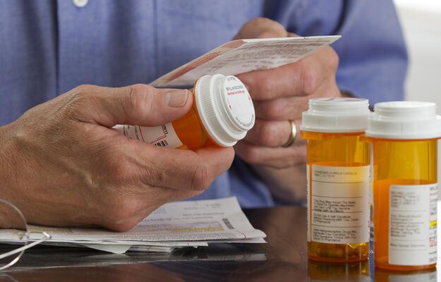 A person holding their prescription medications. 