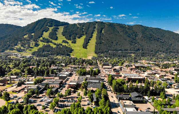 Image of a small mountain town at the bottom of a mountain on a sunny day