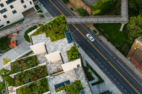 An aerial image of a road and building with a garden on top