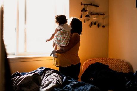 A mother and her child staring out a sunny window