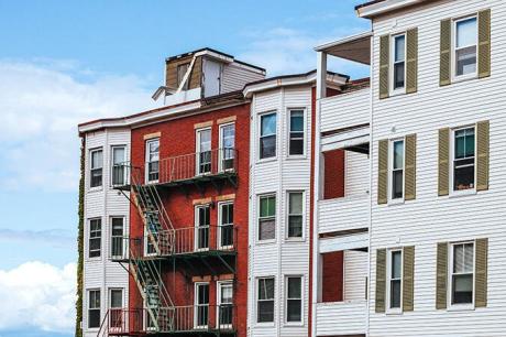 Three apartment buildings against a cloudy blue skyline